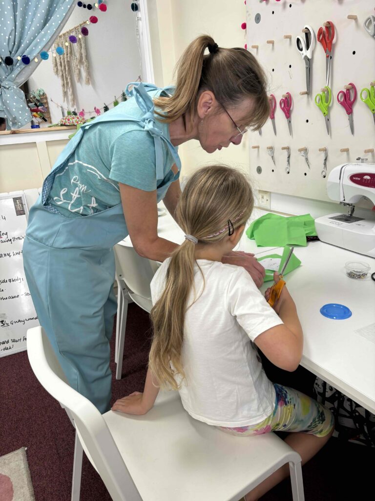 Adult and child working on a crafting project at Pom Stitch Tassel