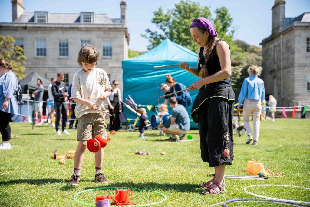 Family playing with circus skills equipment at Royal William Yard in Plymouth